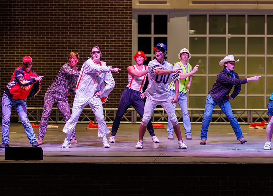 Students dressed in funny outfits perform.