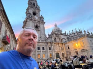 Selfie of a man in a blue shirt in front of a building in Italy.